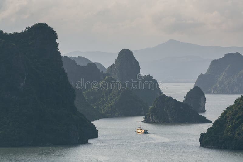 Turist- segling för kryssningskepp bland kalkstenberg i den Halong fjärden, Vietnam fotografering för bildbyråer Turist- segling för kryssningskepp bland kalkstenberg i den Halong fjärden, Vietnam fotografering för bildbyråer