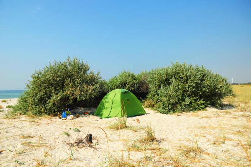 Turist- tält i den härliga inspirerande havsstranden Campa tält på den hemtrevliga sandstranden arkivbild