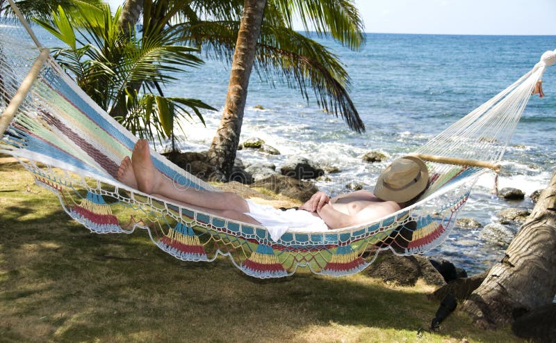 Turista adormecido no hammock pelo mar do Cararibe