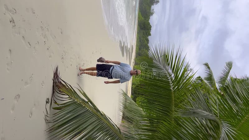 Turista caminando en una playa de arena durante el día del viento