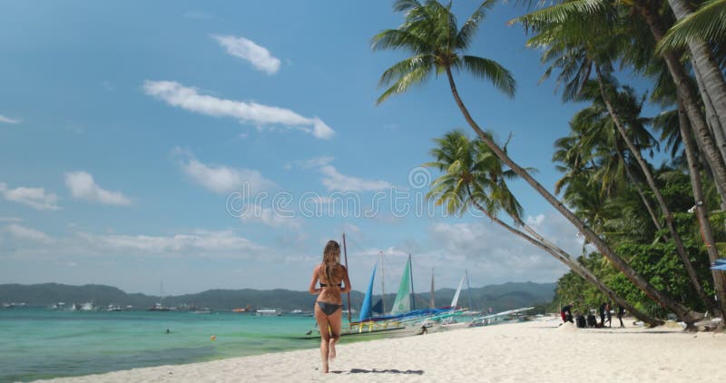 Turista che corre sulla spiaggia bianca sulle filippine di Boracay stock footage