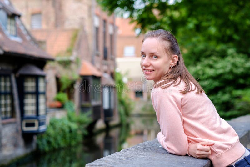 Turista della donna vicino al canale dell'acqua di Bruges, Fiandre, Belgio fotografie stock Turista della donna vicino al canale dell'acqua di Bruges, Fiandre, Belgio fotografie stock