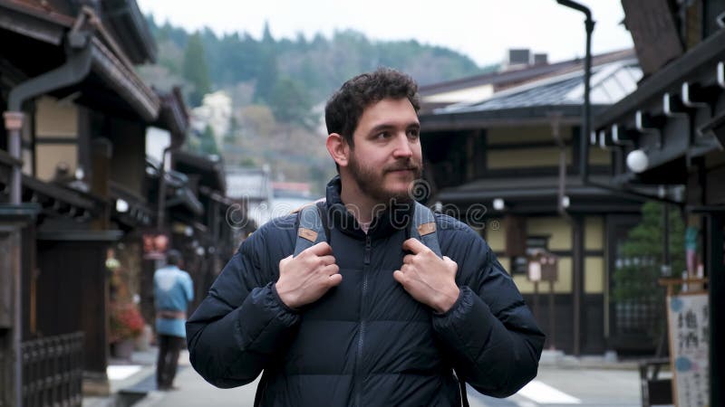 Turista europeo feliz visitando una calle tradicional en takayama japón.