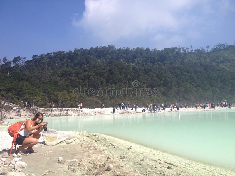 Turista femenino que toma las fotos dentro del cráter de un volcán, Indonesia imagen de archivo libre de regalías Turista femenino que toma las fotos dentro del cráter de un volcán, Indonesia imagen de archivo libre de regalías