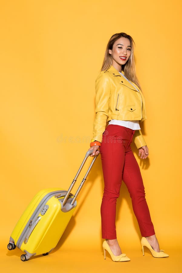 turista fêmea asiático novo com o saco rodado no amarelo fotografia de stock royalty free turista fêmea asiático novo com o saco rodado no amarelo fotografia de stock royalty free