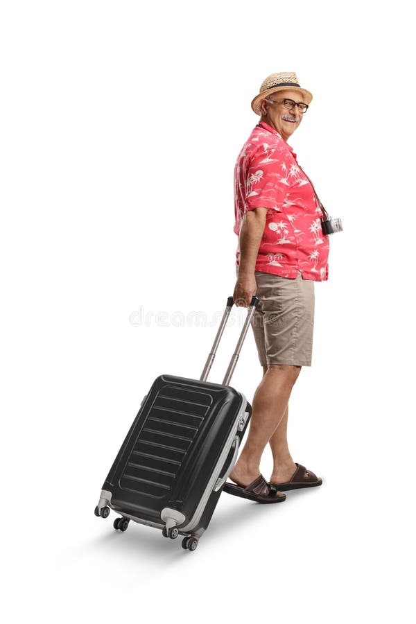 Turista masculino sacando maletas y sonriendo foto de archivo
