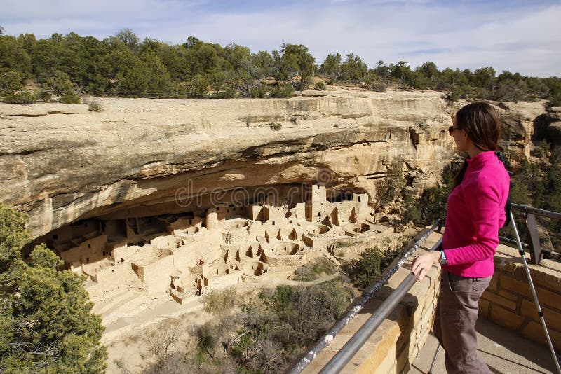 Turista que olha Cliff Palace, Mesa Verde National Park, cor imagens de stock royalty free Turista que olha Cliff Palace, Mesa Verde National Park, cor imagens de stock royalty free
