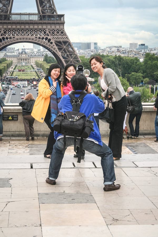 Turistas chineses que tomam fotos na frente da torre Eiffel A excursão Eiffel é uma das atrações principais de Paris fotos de stock royalty free Turistas chineses que tomam fotos na frente da torre Eiffel A excursão Eiffel é uma das atrações principais de Paris fotos de stock royalty free