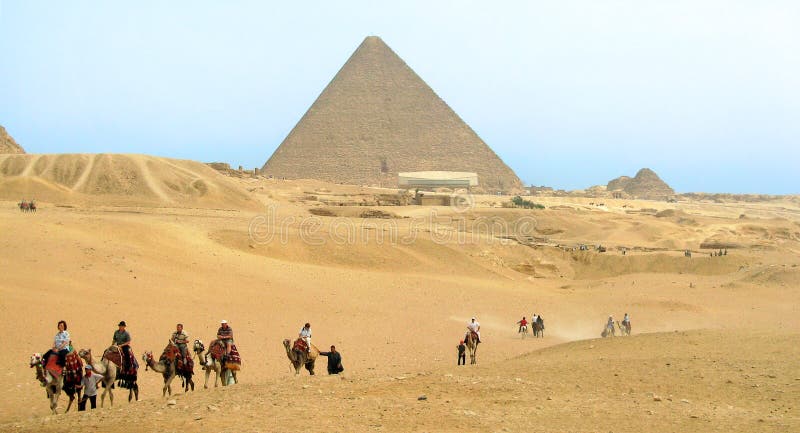 Turistas en camellos delante de la pirámide de Cheops