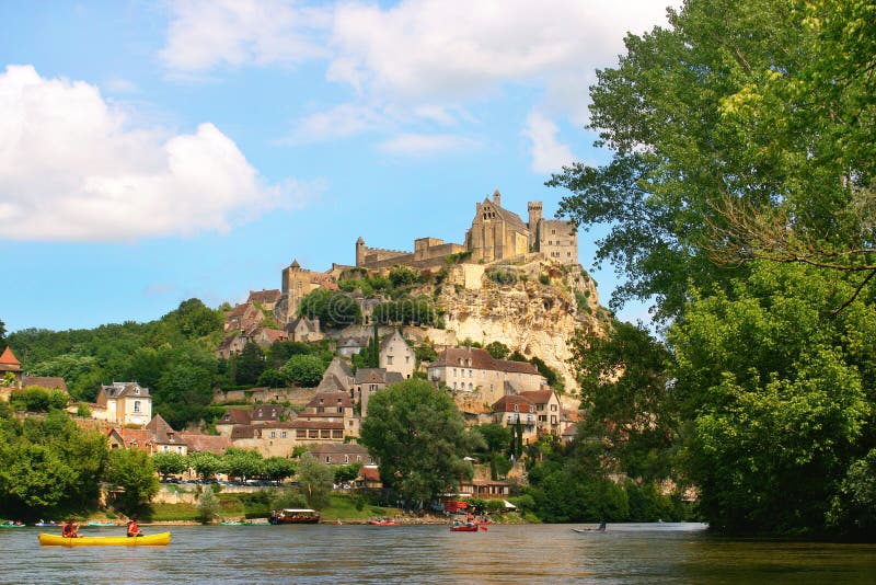 Tourists kayaking on river Dordogne with ChÃ¢teau de Beynac in the background as seen in Beynac-et-Cazenac, Southern France. Tourists kayaking on river Dordogne with ChÃ¢teau de Beynac in the background as seen in Beynac-et-Cazenac, Southern France.