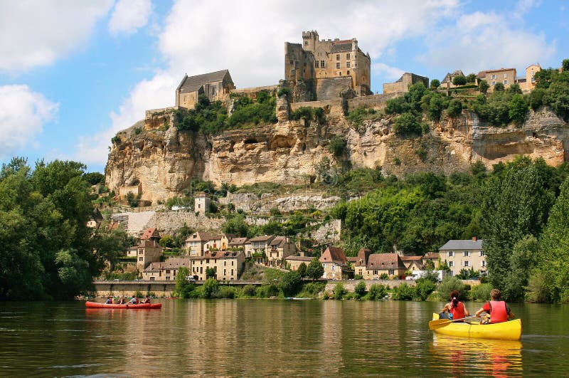 Tourists kayaking on river Dordogne with ChÃ¢teau de Beynac in the background as seen in Beynac-et-Cazenac, Southern France. Tourists kayaking on river Dordogne with ChÃ¢teau de Beynac in the background as seen in Beynac-et-Cazenac, Southern France.