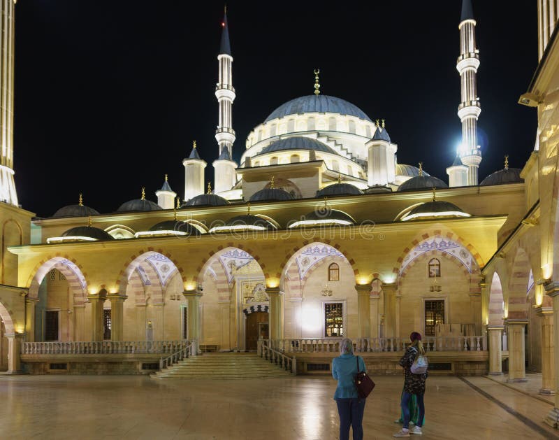 Turistas na zona aberta do coração da mesquita de Chechnya Noite bonita que ilumina atrações populares fotos de stock Turistas na zona aberta do coração da mesquita de Chechnya Noite bonita que ilumina atrações populares fotos de stock