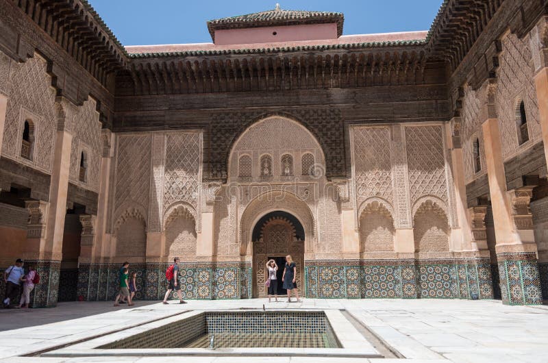 Turistas no pátio interno de Medersa de Ben Youssef, C4marraquexe imagens de stock Turistas no pátio interno de Medersa de Ben Youssef, C4marraquexe imagens de stock