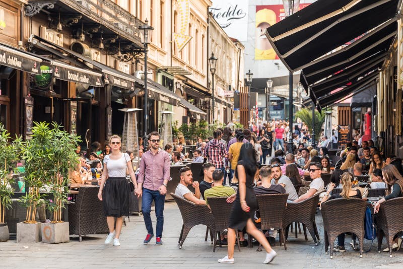 Turistas que visitan y que almuerzan en el café al aire libre del restaurante imagenes de archivo Turistas que visitan y que almuerzan en el café al aire libre del restaurante imagenes de archivo