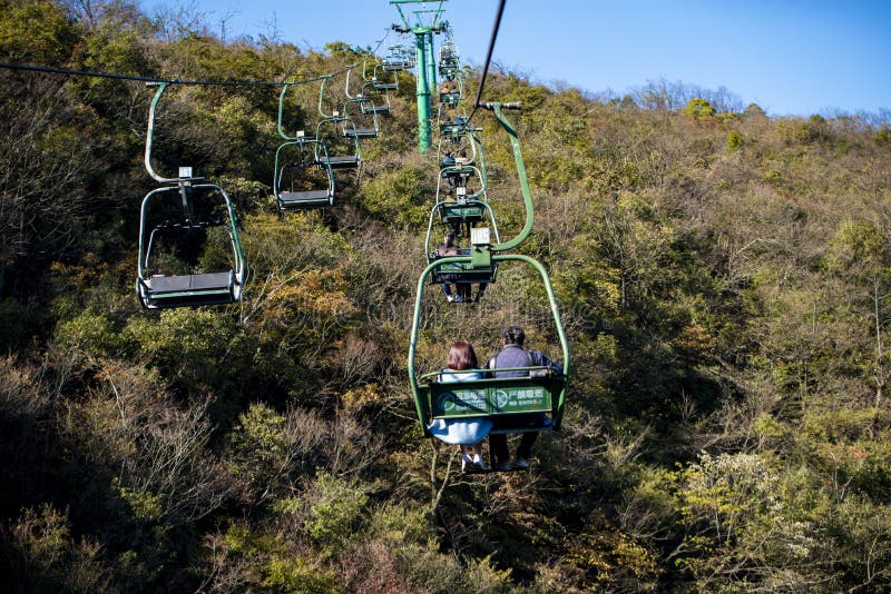 Tourists sitting on the cable car. Cable cars without protective glasses at Tianmenshan, Hunan province, Zhangjiajie. Tourists sitting on the cable car. Cable cars without protective glasses at Tianmenshan, Hunan province, Zhangjiajie.