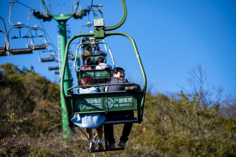 Tourists sitting on the cable car. Cable cars without protective glasses at Tianmenshan, Hunan province, Zhangjiajie. Tourists sitting on the cable car. Cable cars without protective glasses at Tianmenshan, Hunan province, Zhangjiajie.