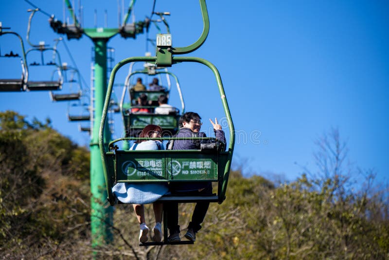 Tourists sitting on the cable car. Cable cars without protective glasses at Tianmenshan, Hunan province, Zhangjiajie. Tourists sitting on the cable car. Cable cars without protective glasses at Tianmenshan, Hunan province, Zhangjiajie.