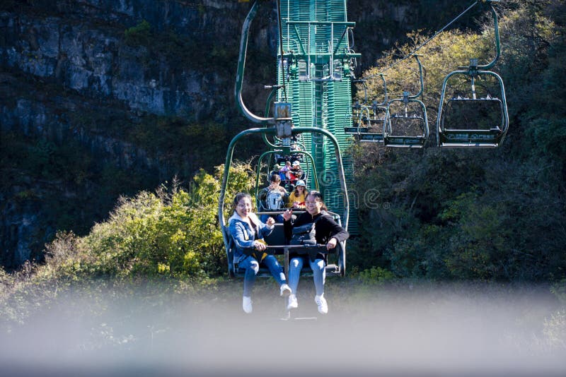 Tourists sitting on the cable car. Cable cars without protective glasses at Tianmenshan, Hunan province, Zhangjiajie. Tourists sitting on the cable car. Cable cars without protective glasses at Tianmenshan, Hunan province, Zhangjiajie.