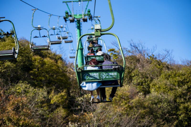 Tourists sitting on the cable car. Cable cars without protective glasses at Tianmenshan, Hunan province, Zhangjiajie. Tourists sitting on the cable car. Cable cars without protective glasses at Tianmenshan, Hunan province, Zhangjiajie.