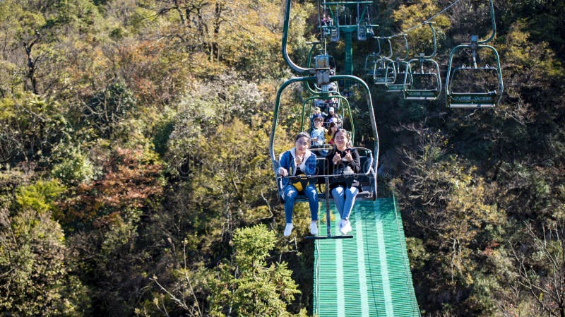 Tourists sitting on the cable car. Cable cars without protective glasses at Tianmenshan, Hunan province, Zhangjiajie. Tourists sitting on the cable car. Cable cars without protective glasses at Tianmenshan, Hunan province, Zhangjiajie.