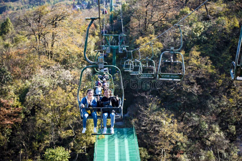 Tourists sitting on the cable car. Cable cars without protective glasses at Tianmenshan, Hunan province, Zhangjiajie. Tourists sitting on the cable car. Cable cars without protective glasses at Tianmenshan, Hunan province, Zhangjiajie.