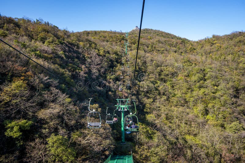 Tourists sitting on the cable car. Cable cars without protective glasses at Tianmenshan, Hunan province, Zhangjiajie. Tourists sitting on the cable car. Cable cars without protective glasses at Tianmenshan, Hunan province, Zhangjiajie.