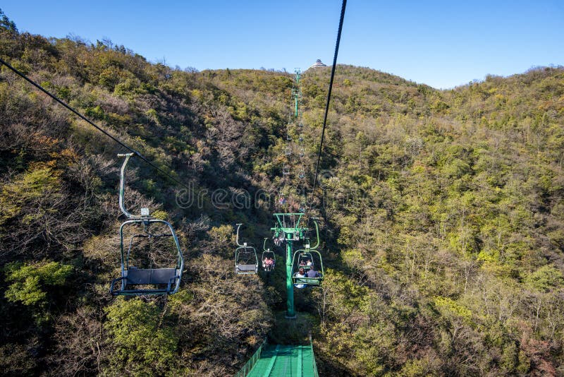 Tourists sitting on the cable car. Cable cars without protective glasses at Tianmenshan, Hunan province, Zhangjiajie. Tourists sitting on the cable car. Cable cars without protective glasses at Tianmenshan, Hunan province, Zhangjiajie.