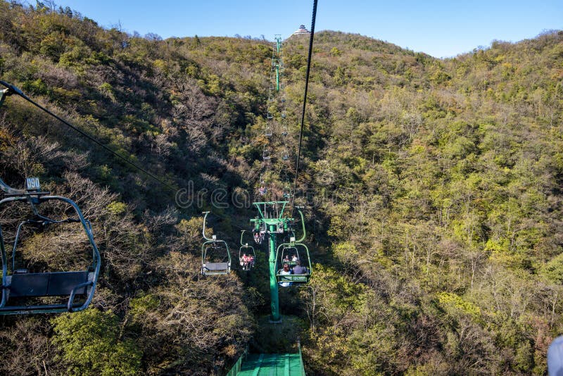 Tourists sitting on the cable car. Cable cars without protective glasses at Tianmenshan, Hunan province, Zhangjiajie. Tourists sitting on the cable car. Cable cars without protective glasses at Tianmenshan, Hunan province, Zhangjiajie.