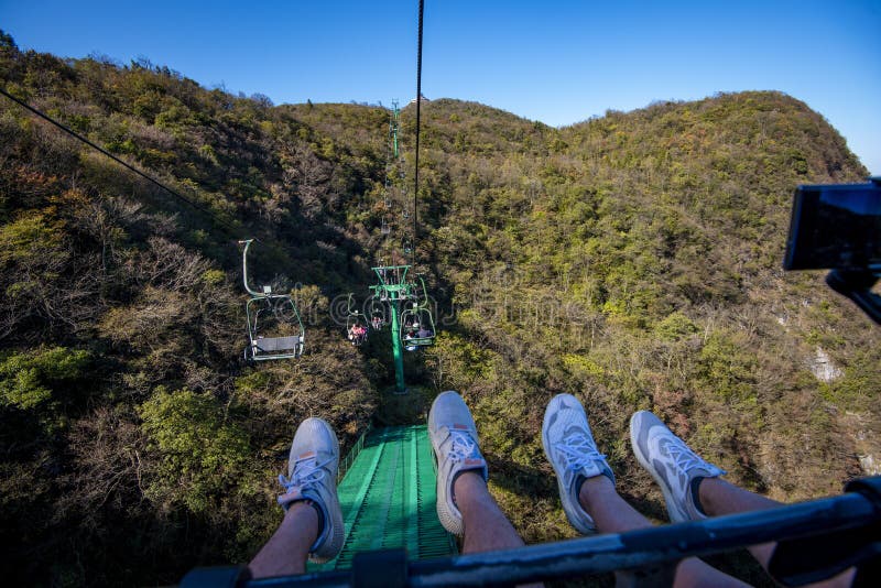 Tourists sitting on the cable car. Cable cars without protective glasses at Tianmenshan, Hunan province, Zhangjiajie. Tourists sitting on the cable car. Cable cars without protective glasses at Tianmenshan, Hunan province, Zhangjiajie.