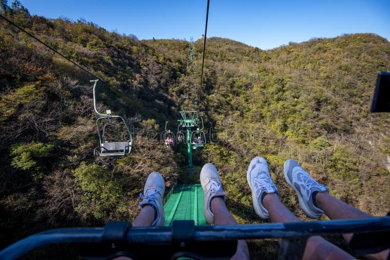 Tourists sitting on the cable car. Cable cars without protective glasses at Tianmenshan, Hunan province, Zhangjiajie. Tourists sitting on the cable car. Cable cars without protective glasses at Tianmenshan, Hunan province, Zhangjiajie.