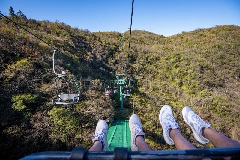 Tourists sitting on the cable car. Cable cars without protective glasses at Tianmenshan, Hunan province, Zhangjiajie. Tourists sitting on the cable car. Cable cars without protective glasses at Tianmenshan, Hunan province, Zhangjiajie.