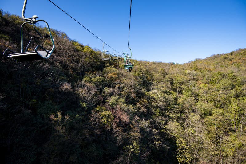 Tourists sitting on the cable car. Cable cars without protective glasses at Tianmenshan, Hunan province, Zhangjiajie. Tourists sitting on the cable car. Cable cars without protective glasses at Tianmenshan, Hunan province, Zhangjiajie.