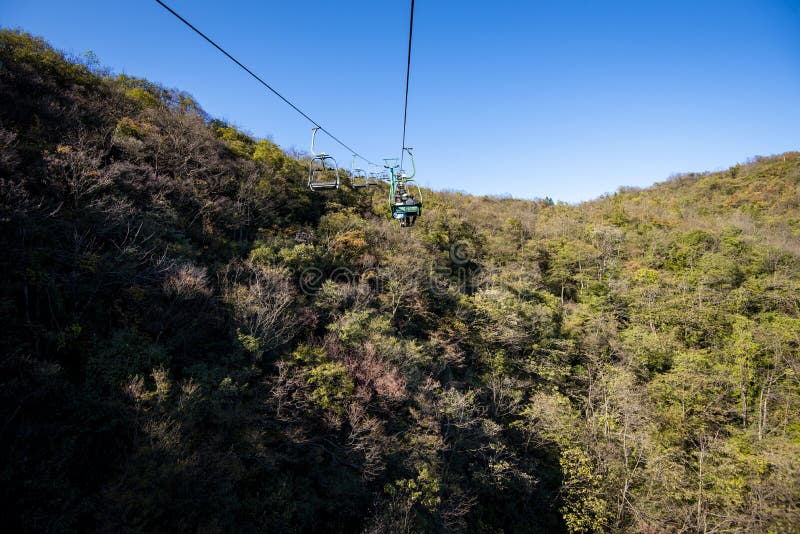 Tourists sitting on the cable car. Cable cars without protective glasses at Tianmenshan, Hunan province, Zhangjiajie. Tourists sitting on the cable car. Cable cars without protective glasses at Tianmenshan, Hunan province, Zhangjiajie.