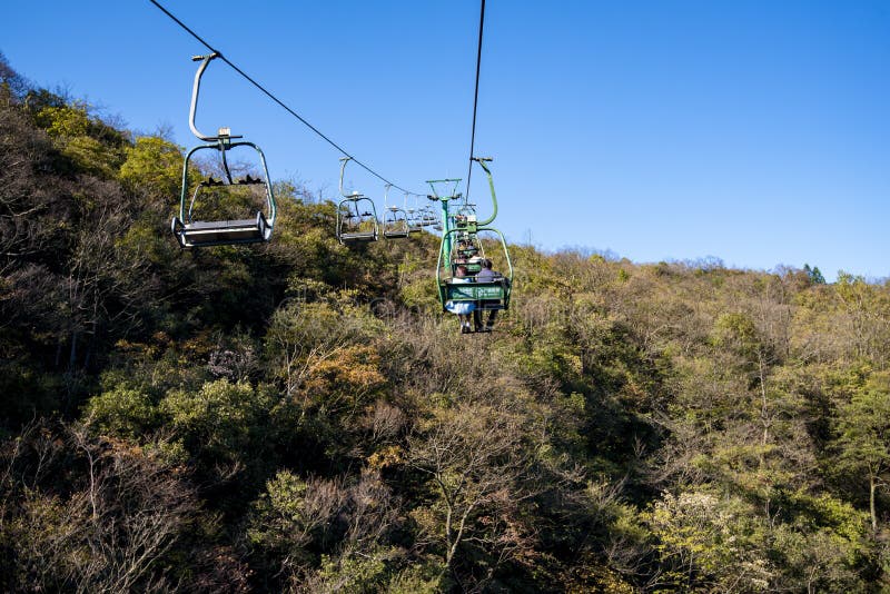 Tourists sitting on the cable car. Cable cars without protective glasses at Tianmenshan, Hunan province, Zhangjiajie. Tourists sitting on the cable car. Cable cars without protective glasses at Tianmenshan, Hunan province, Zhangjiajie.