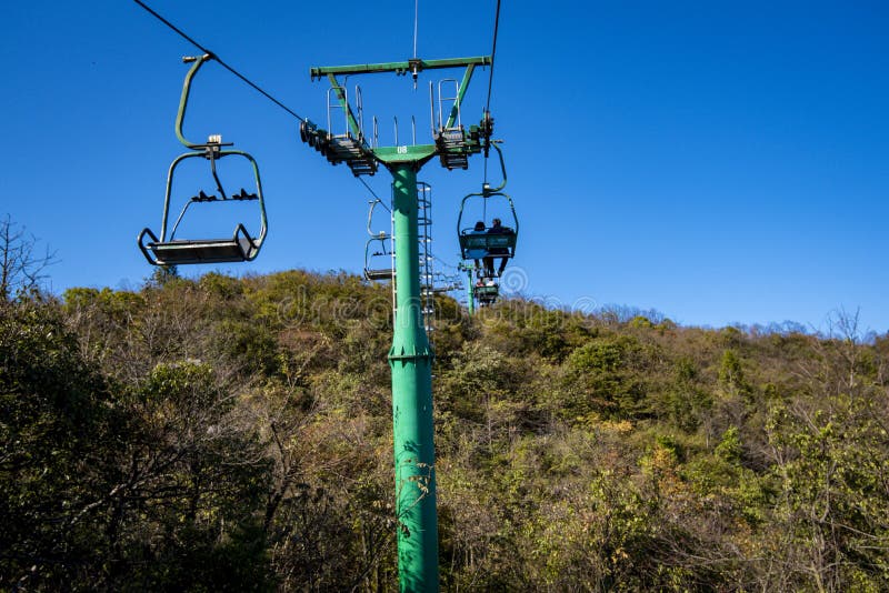 Tourists sitting on the cable car. Cable cars without protective glasses at Tianmenshan, Hunan province, Zhangjiajie. Tourists sitting on the cable car. Cable cars without protective glasses at Tianmenshan, Hunan province, Zhangjiajie.