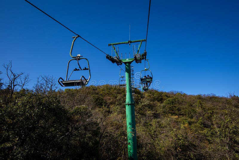 Tourists sitting on the cable car. Cable cars without protective glasses at Tianmenshan, Hunan province, Zhangjiajie. Tourists sitting on the cable car. Cable cars without protective glasses at Tianmenshan, Hunan province, Zhangjiajie.