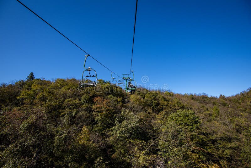 Tourists sitting on the cable car. Cable cars without protective glasses at Tianmenshan, Hunan province, Zhangjiajie. Tourists sitting on the cable car. Cable cars without protective glasses at Tianmenshan, Hunan province, Zhangjiajie.