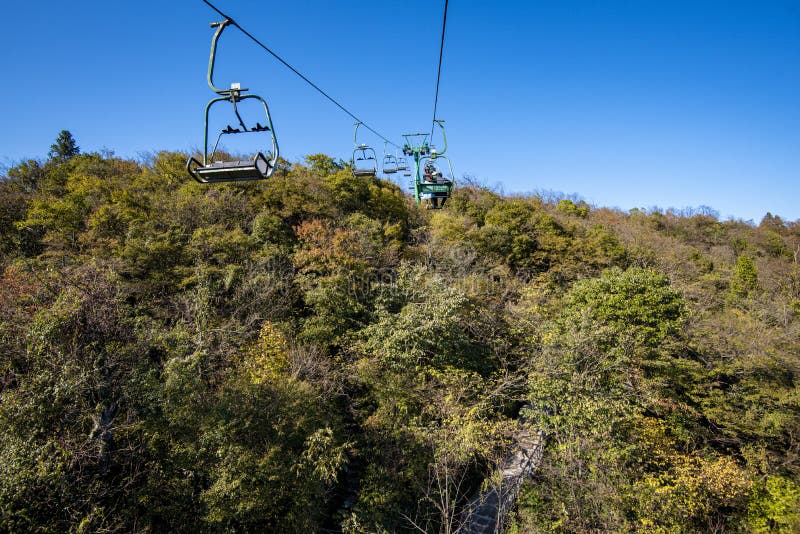 Tourists sitting on the cable car. Cable cars without protective glasses at Tianmenshan, Hunan province, Zhangjiajie. Tourists sitting on the cable car. Cable cars without protective glasses at Tianmenshan, Hunan province, Zhangjiajie.