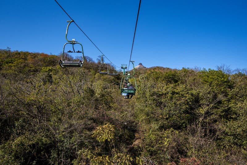 Tourists sitting on the cable car. Cable cars without protective glasses at Tianmenshan, Hunan province, Zhangjiajie. Tourists sitting on the cable car. Cable cars without protective glasses at Tianmenshan, Hunan province, Zhangjiajie.