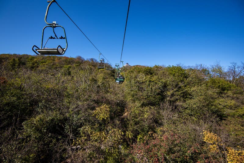 Tourists sitting on the cable car. Cable cars without protective glasses at Tianmenshan, Hunan province, Zhangjiajie. Tourists sitting on the cable car. Cable cars without protective glasses at Tianmenshan, Hunan province, Zhangjiajie.