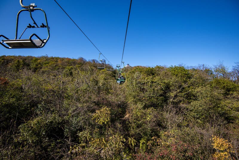 Tourists sitting on the cable car. Cable cars without protective glasses at Tianmenshan, Hunan province, Zhangjiajie. Tourists sitting on the cable car. Cable cars without protective glasses at Tianmenshan, Hunan province, Zhangjiajie.