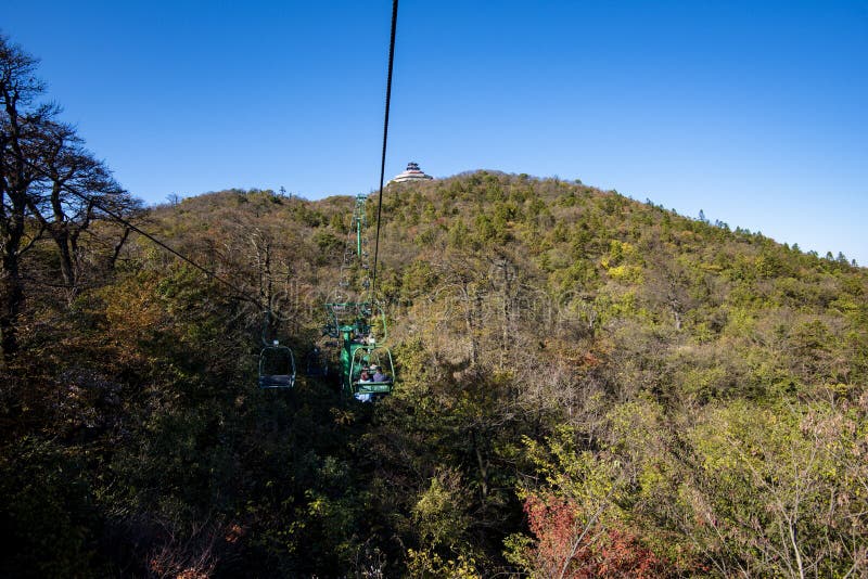 Tourists sitting on the cable car. Cable cars without protective glasses at Tianmenshan, Hunan province, Zhangjiajie. Tourists sitting on the cable car. Cable cars without protective glasses at Tianmenshan, Hunan province, Zhangjiajie.