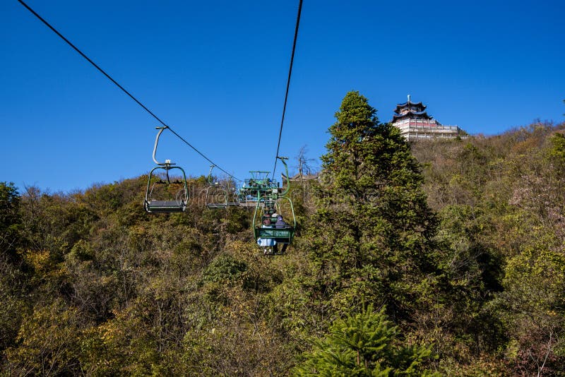 Tourists sitting on the cable car. Cable cars without protective glasses at Tianmenshan, Hunan province, Zhangjiajie. Tourists sitting on the cable car. Cable cars without protective glasses at Tianmenshan, Hunan province, Zhangjiajie.