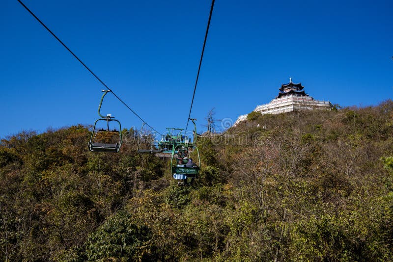 Tourists sitting on the cable car. Cable cars without protective glasses at Tianmenshan, Hunan province, Zhangjiajie. Tourists sitting on the cable car. Cable cars without protective glasses at Tianmenshan, Hunan province, Zhangjiajie.