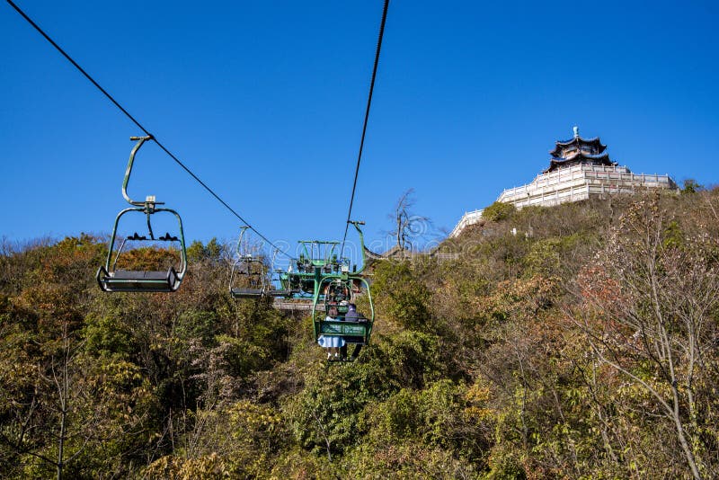 Tourists sitting on the cable car. Cable cars without protective glasses at Tianmenshan, Hunan province, Zhangjiajie. Tourists sitting on the cable car. Cable cars without protective glasses at Tianmenshan, Hunan province, Zhangjiajie.