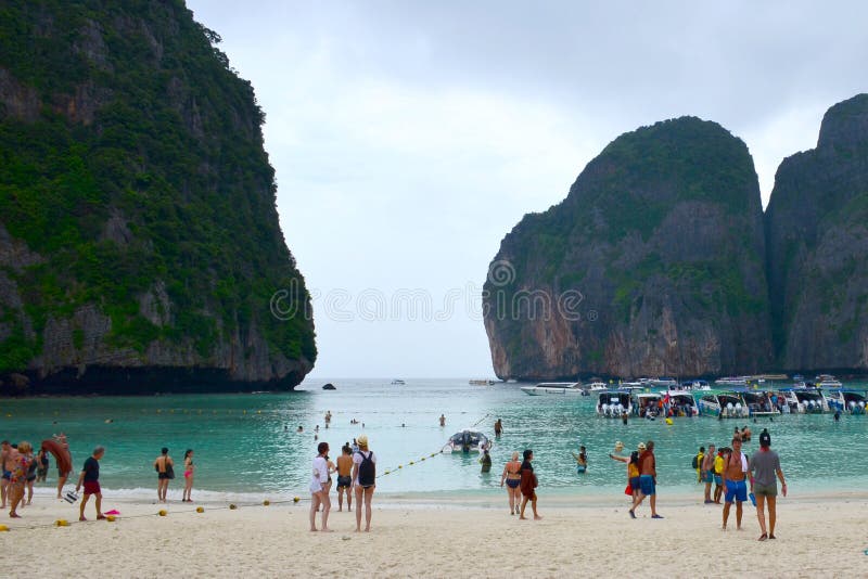Turistas y barcos turísticos en la playa famosa en Maya Bay en una de las islas de Phi Phi, Tailandia imagenes de archivo Turistas y barcos turísticos en la playa famosa en Maya Bay en una de las islas de Phi Phi, Tailandia imagenes de archivo