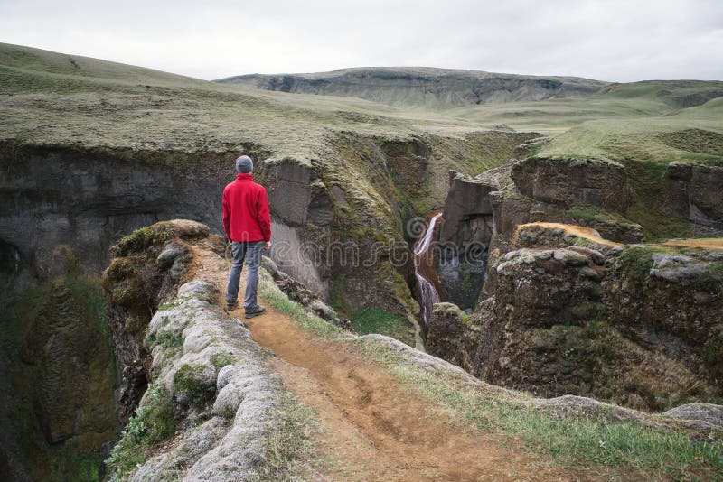 Turisten beskådar kanjonen i Island royaltyfri foto Turisten beskådar kanjonen i Island royaltyfri foto