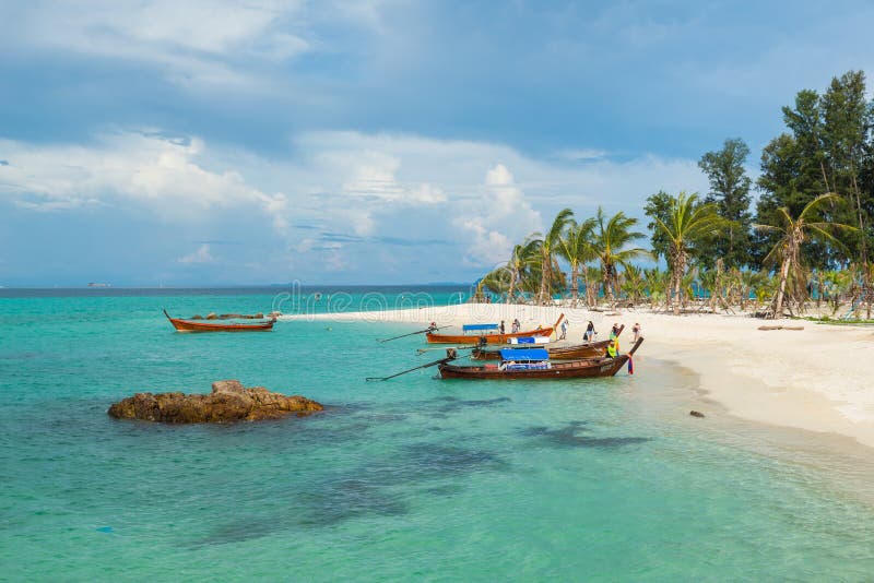 Turisten går till den Koh Lipe soluppgångstranden med longtailfartyget fotografering för bildbyråer Turisten går till den Koh Lipe soluppgångstranden med longtailfartyget fotografering för bildbyråer