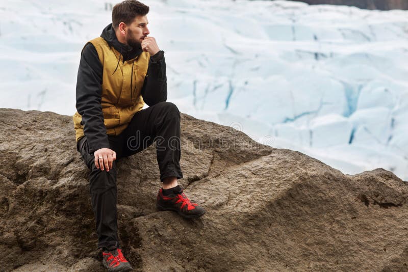Turisten sitter nära glaciärisberget i Island arkivbilder Turisten sitter nära glaciärisberget i Island arkivbilder