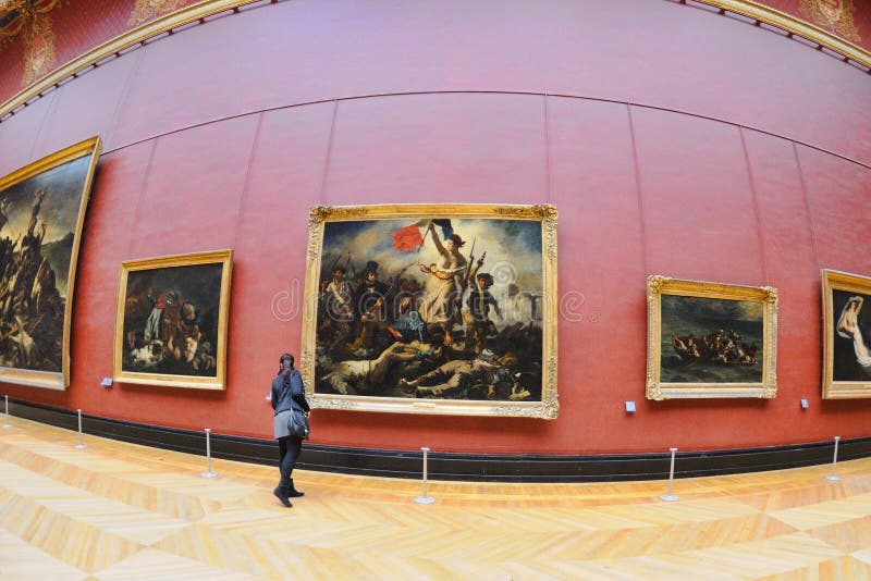 Turister ser målningarna av Eugene Delacroix på Louvremuseet royaltyfri bild Turister ser målningarna av Eugene Delacroix på Louvremuseet royaltyfri bild